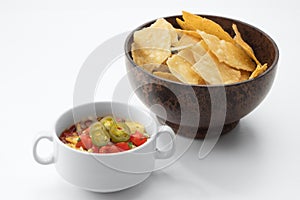 Nice red salsa and corn chips on white background.