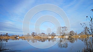 Nice river with smooth water surface and trees in frost