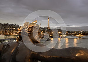 Nice scenery of Golden statue adorning Pont Alexandre III Bridge over the Seine River and Eiffel Tower in Paris at sunset