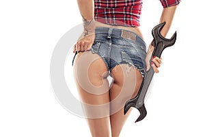 Nice woman mechanic showing buttock and holding wrenc photo