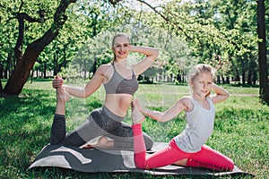 Nice shot of girls excercising together. They are sitting on left leg and stretchin the right one with right hand. Also