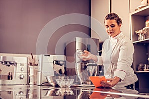 Nice skilled chef looking at the tablet screen