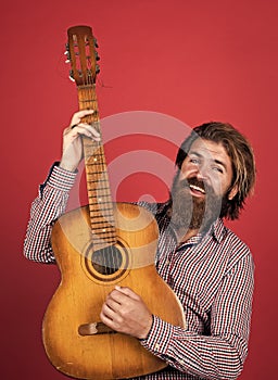 nice smile. mature charismatic male guitarist. guy with beard and moustache play guitar. bearded man in checkered shirt
