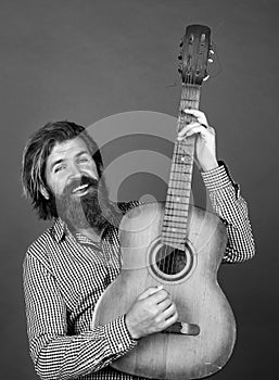 nice smile. mature charismatic male guitarist. guy with beard and moustache play guitar. bearded man in checkered shirt