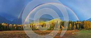 Nice summer rainbow over the mountains. Amazing rainy and cloudy day. Canadian Rocky Mountains, Canada.