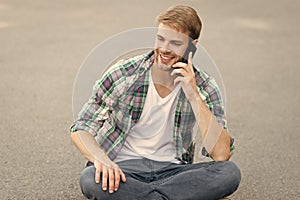 Nice talk. man sit on ground. carefree student. free time spending. summer fashion. handsome man checkered shirt. male