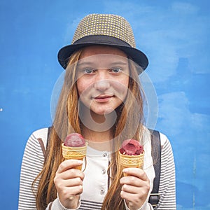 Nice teen girl with ice cream, blue wall background (Instagram style series)