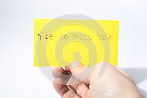 Nice to meet you handwrite with a hand on a yellow paper