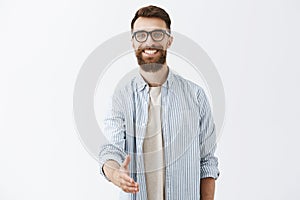 Nice to meet you pal. Portrait of friendly-looking charming caucasian guy with long stylish beard and hairstyle pulling