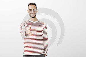 Nice to meet you. Portrait of friendly confident adult businessman in striped pullover, pulling hand towards camera in