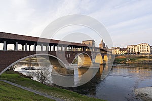 Nice view of covered bridge and Pavia Cathedral in background at sunny day in Pavia
