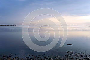 Nice view of the estuary. Sunset over the sea. Calm sea surface.