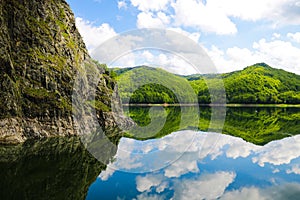 Nice view of the mountains and green hills. Reflection of hills in a lake photo