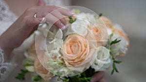 Nice wedding bouquet in bride`s hand. Clip. Fiancee in a beautiful white dress holding a beautiful bouquet of wedding