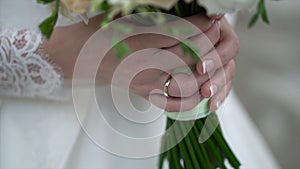 Nice wedding bouquet in bride`s hand. Clip. Fiancee in a beautiful white dress holding a beautiful bouquet of wedding