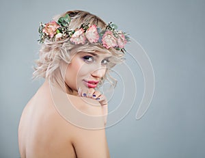 Nice woman with healthy skin, makeup, flowers and short curly haircut. Beautiful model portrait