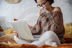 Nice woman holding laptop on legs at home