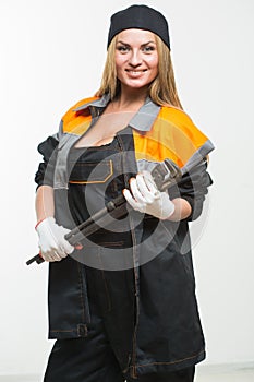 Nice woman mechanic holding wrench isolated over white background