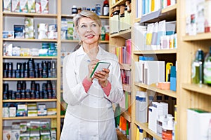 Nice woman seller writing down care products in shop