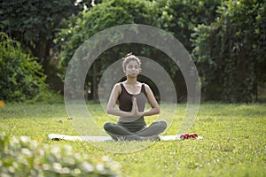 Nice Woman Sitting Cross Legged In The Park While Meditating