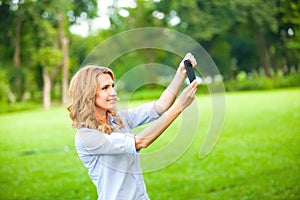 Nice woman taking pictures with smartphone