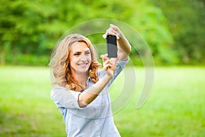 Nice woman taking pictures with smartphone