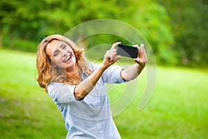 Nice woman taking pictures with smartphone