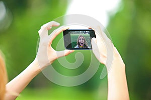 Nice woman taking pictures with smartphone