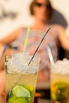 A nice young lady enjoys a mochito during sunset