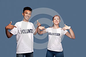 Nice young volunteers pointing at themselves photo