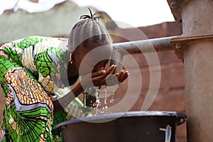 Nicely Braided African Girl Washing Her Face With Fresh Water At the Borehole