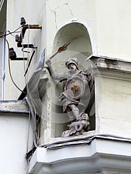 Niche with a stone statue of the angel Saint George with the flaming sword