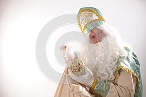 Nicholas the Wonderworker takes out a toy from a bag gold suit long white beard and a hat winter month from a fairy tale