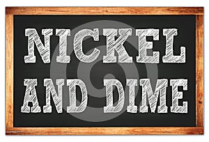 NICKEL AND DIME words on black wooden frame school blackboard