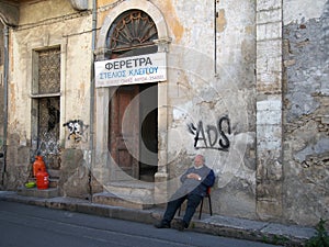 A coffin maker resting outside his workshop in an old crumbling building in the old town of Nicosia cyprus