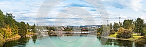 The Nidelva river and a pedestrian bridge with wooden pillars in Trondheim, Trondelag, Norway