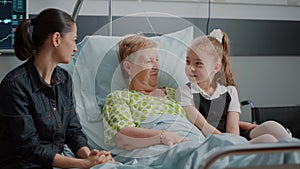 Niece and sick grandma hugging at family visit in hospital ward