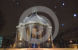 Nieuwe Kerk Den Haag covered in snow at night, while snowing