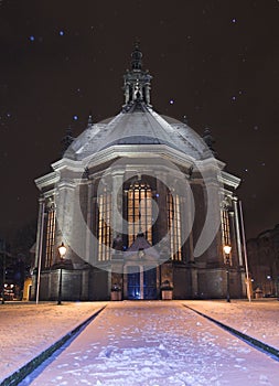 Nieuwe Kerk Den Haag covered in snow at night, while snowing