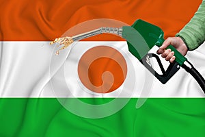 NIGER flag Close-up shot on waving background texture with Fuel pump nozzle in hand. The concept of design solutions. 3d rendering