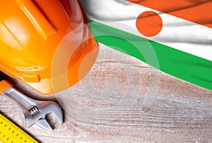 Niger flag with different construction tools on wood background, with copy space for text