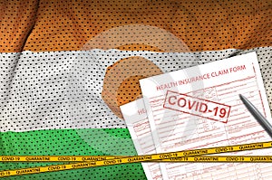 Niger flag and Health insurance claim form with covid-19 stamp. Coronavirus or 2019-nCov virus concept