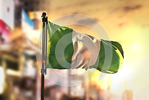Nigeria Flag Against City Blurred Background At Sunrise Backlight photo