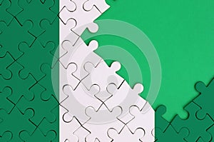 Nigeria flag is depicted on a completed jigsaw puzzle with free green copy space on the right side