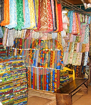 Nigerian fabrics line a market stall