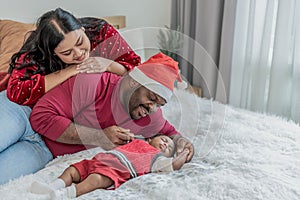 Nigerian father and Asian mother looking, smile happily while looking baby newborn son