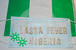 Nigerian flag under words Lassa fever outbreak concept. protective breathing mask and syringe. Lassa hemorrhagic fever LHF endemic