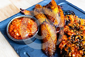 Nigerian Food: Delicious fried plantain with red chilli souce photo