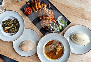 Nigerian Food: Delicious Pounded Yam, Eba, Banga Soup and Efo riro with roasted fish for Lunch photo