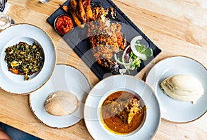 Nigerian Food: Delicious Pounded Yam, Eba, Banga Soup and Efo riro with roasted fish for Lunch